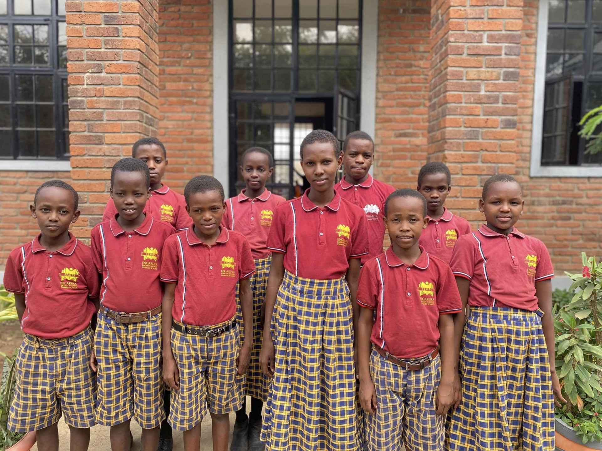 A group of students standing in front of the entrance of a building